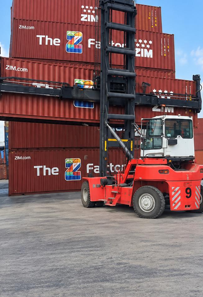 Container handler stacking shipping containers in a terminal yard